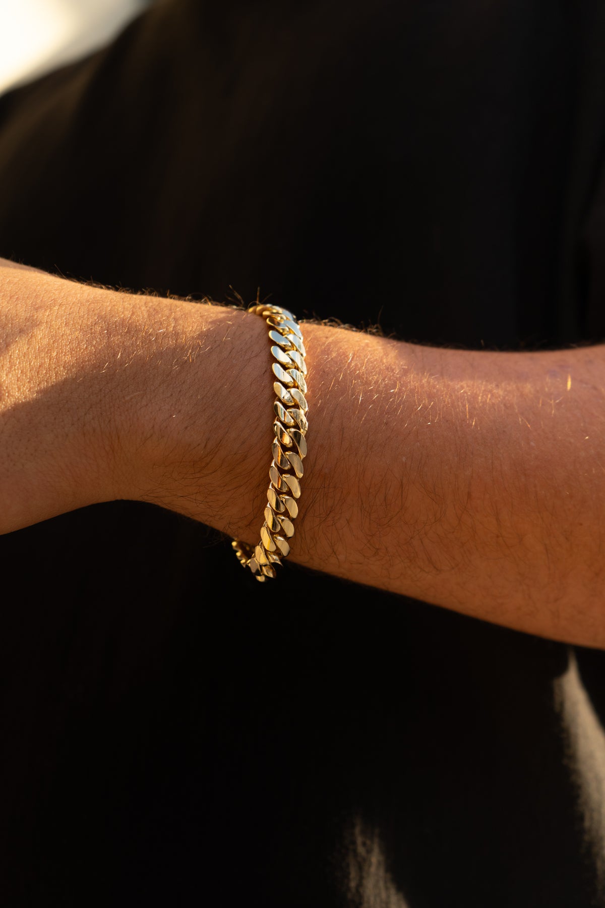 Man wearing 10MM 14KT gold over silver Cuban link bracelet